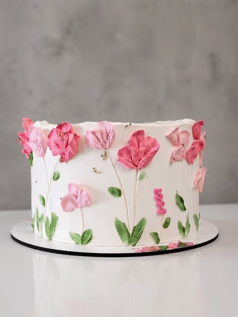 Bolo branco decorado com delicadas flores em tons de rosa